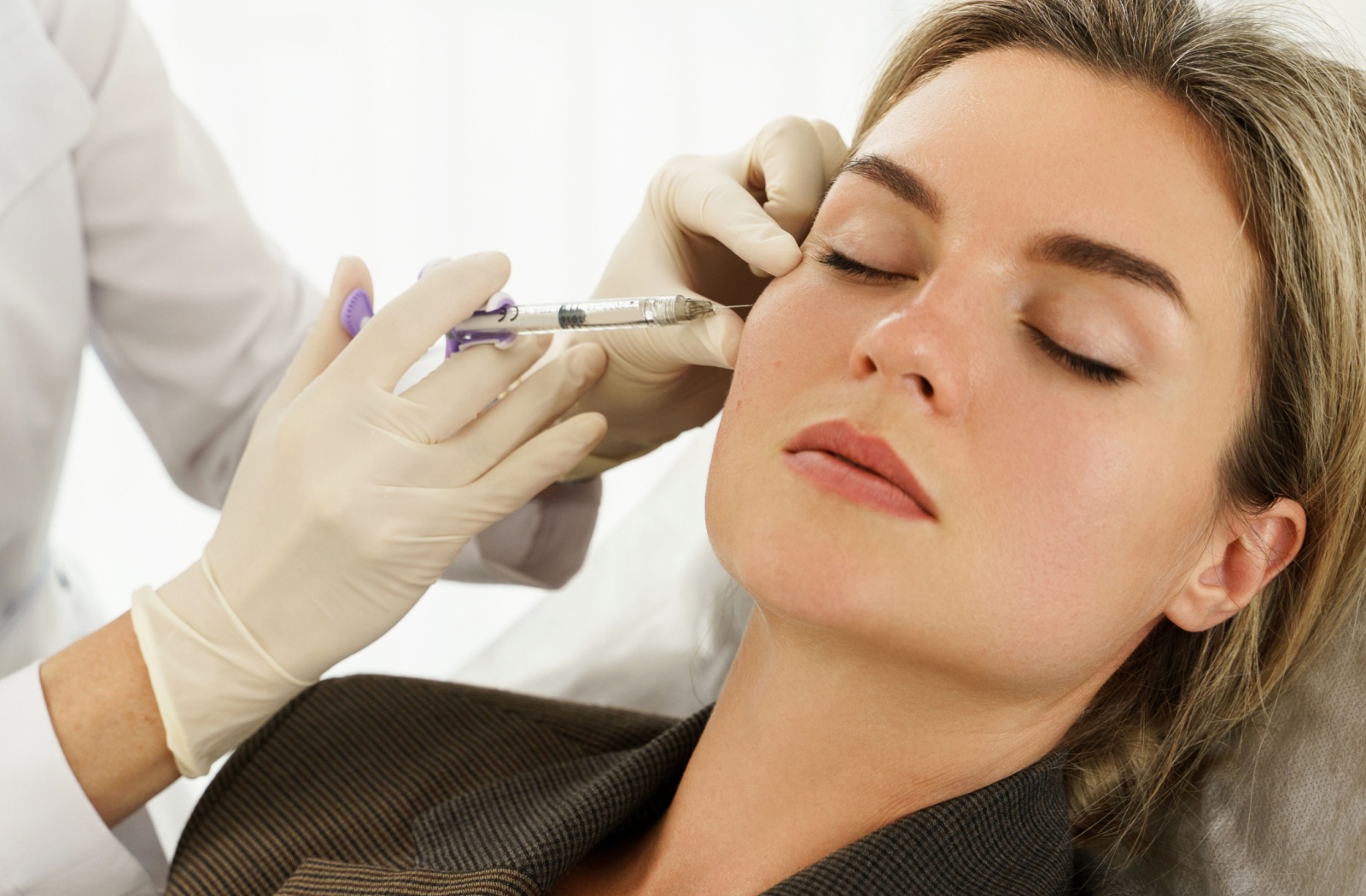 A woman getting dermal fillers for her cheeks