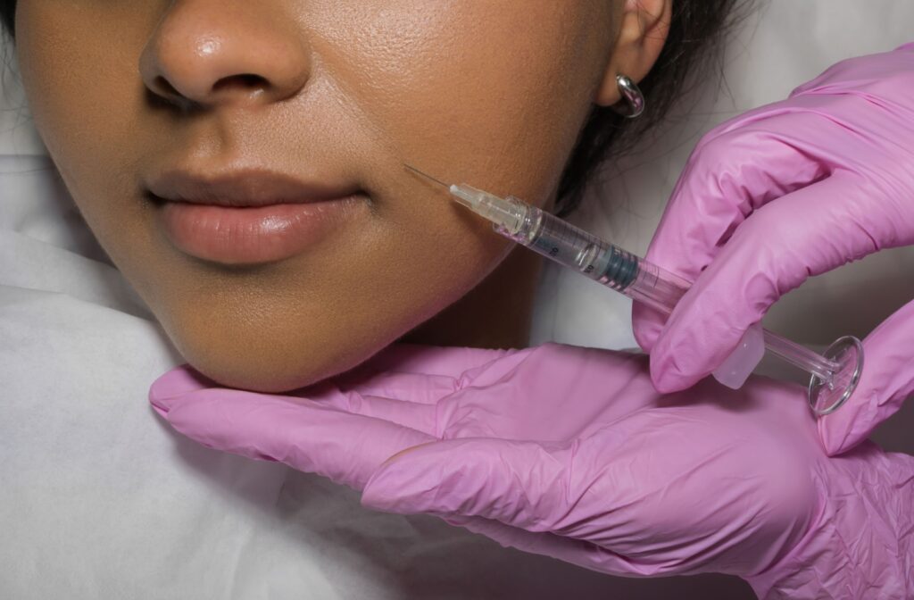 Female patient receiving derma filler injection touch-up in beauty clinic