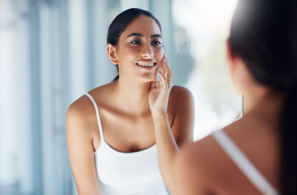 Woman admiring her refreshed, youthful skin after a microneedling treatment, highlighting the procedure's rejuvenating benefits.