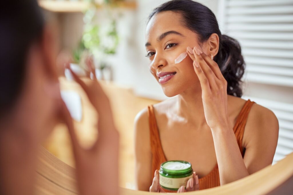 A person applying a topical serum to improve the appearance of mild acne scars over time.