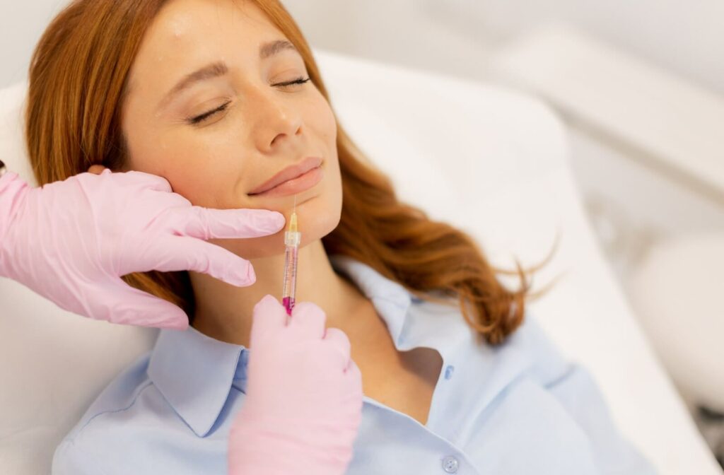 A patient feels relaxed as their practitioner gently injects filler into their lips for a subtle and natural look.