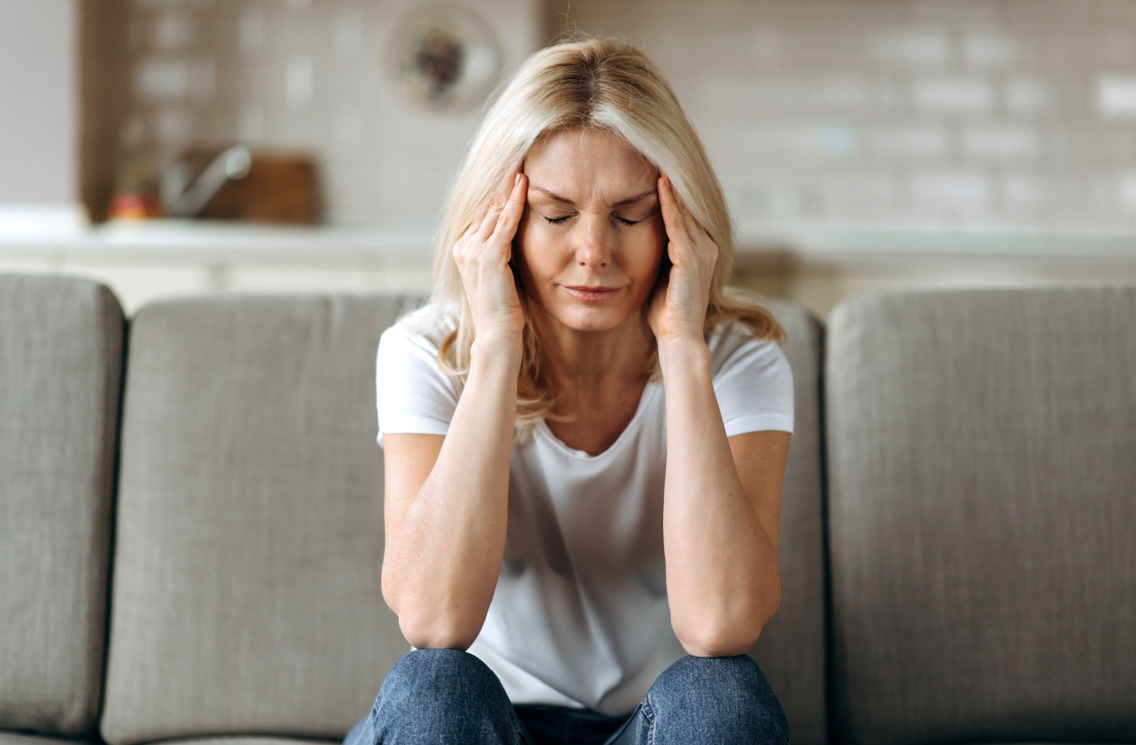 A person soothes their temples to ease migraine pain.